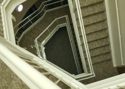 An image of a stairway with a white carpet.