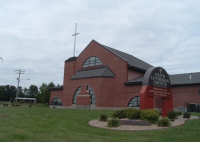 A brick building with a cross in front of it.