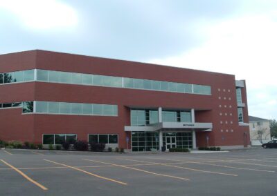 A large office building with a parking lot in front of it.